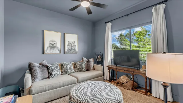 a living room with furniture a flat screen tv and a window