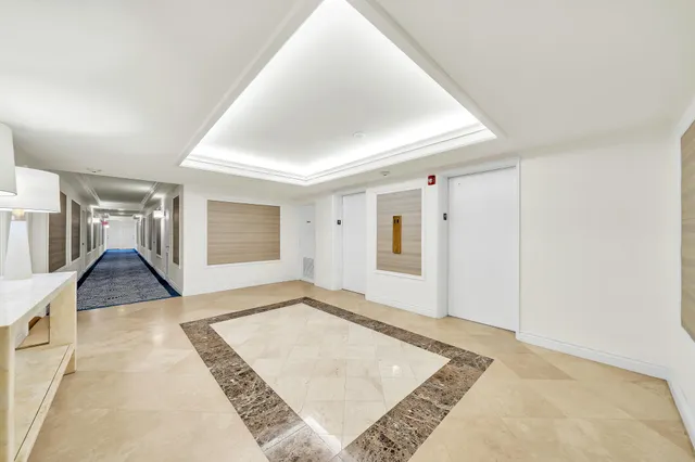 a view of a hallway with wooden floor and a living room