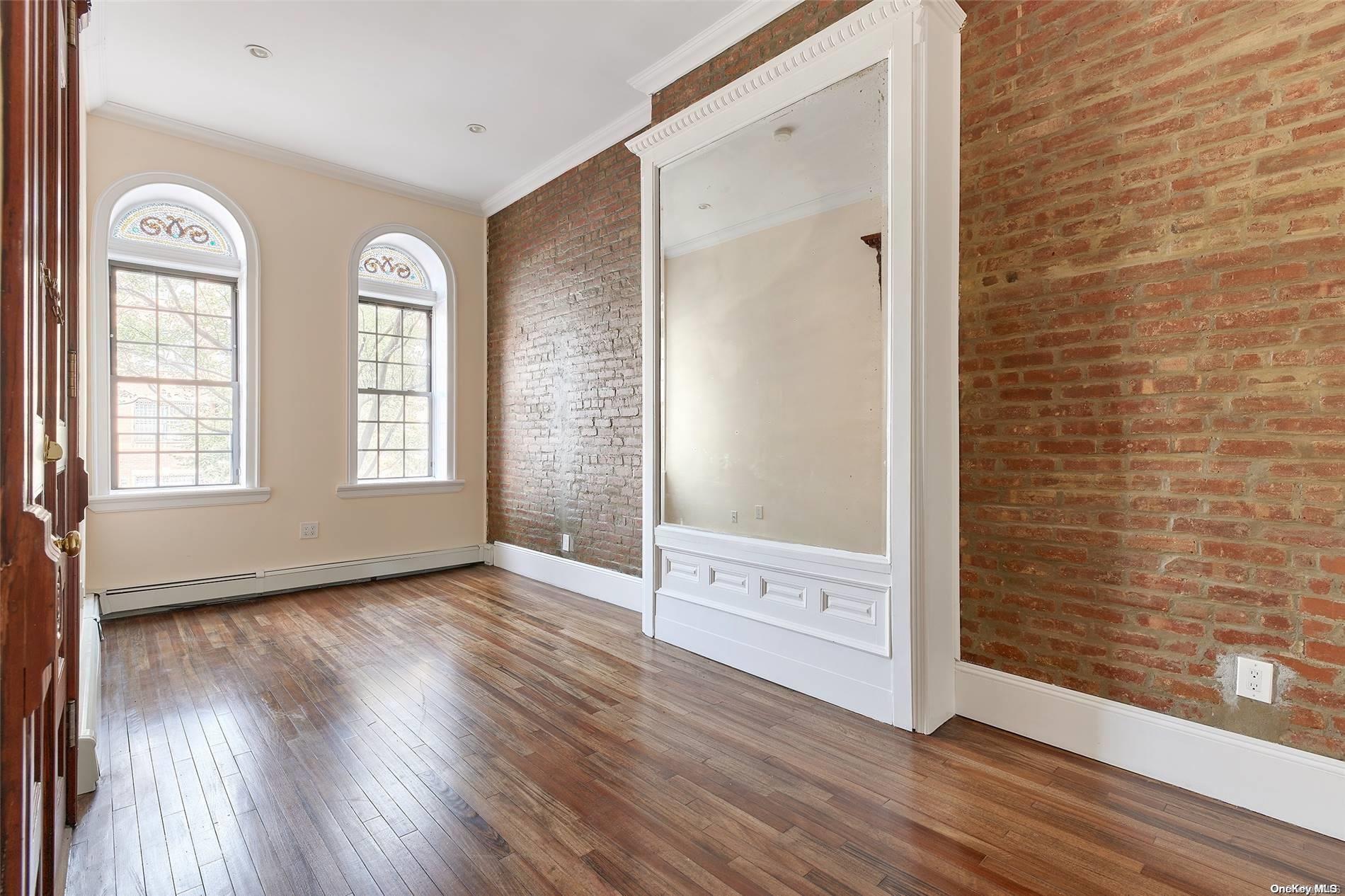 266 West 136th Street Manhattan, NY 10030 - Photo 16 of 22 wooden floor in an empty room with a window