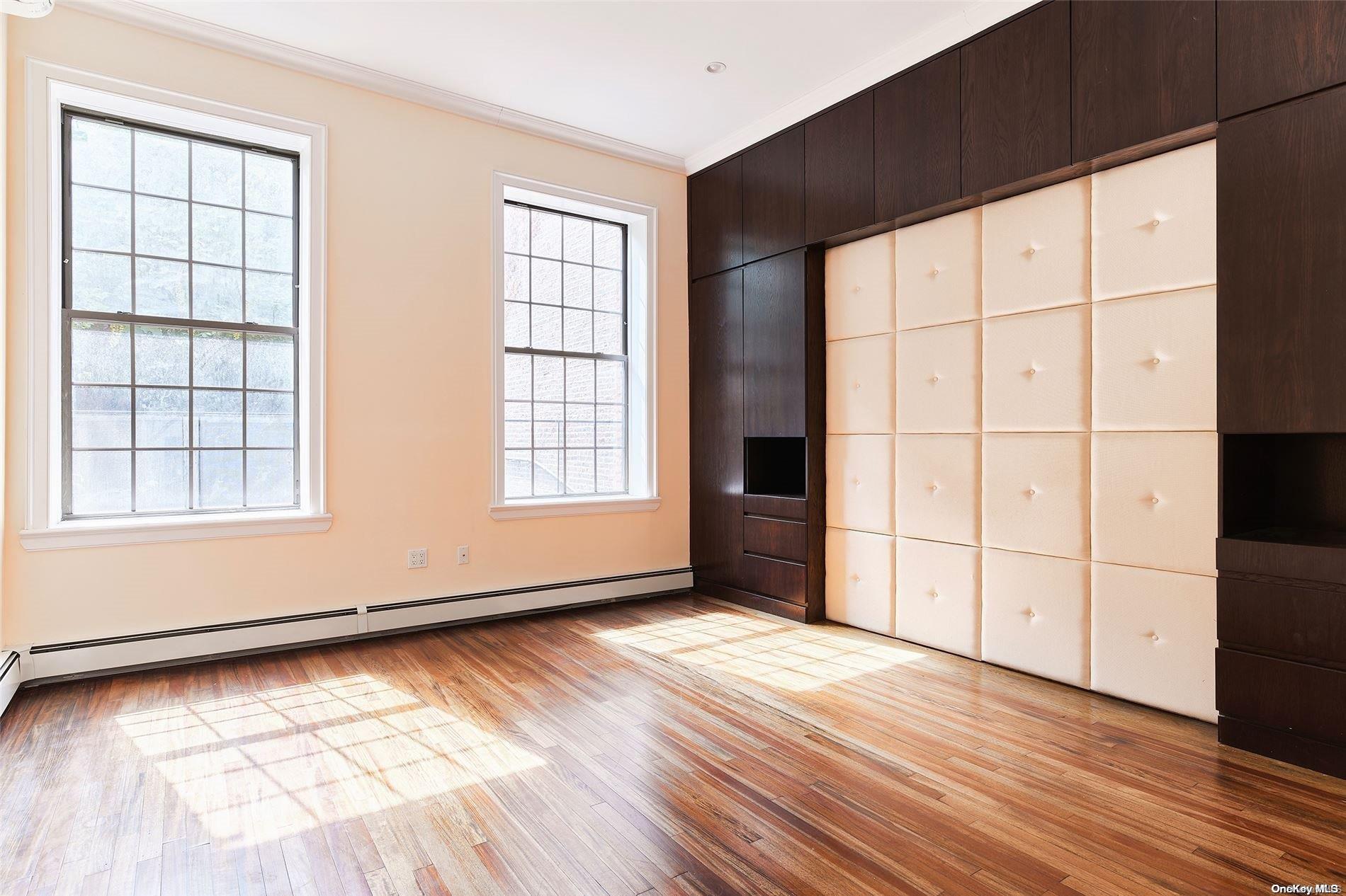 266 West 136th Street Manhattan, NY 10030 - Photo 17 of 22 an empty room with wooden floor and windows