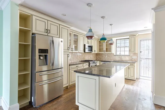 a kitchen with stainless steel appliances granite countertop a refrigerator and a sink