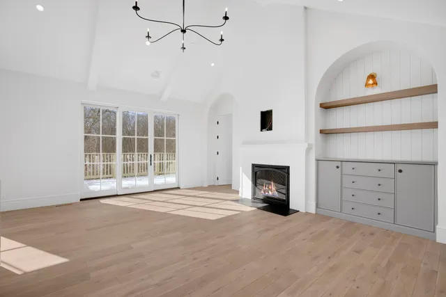 a view of an empty room with a fireplace and a window