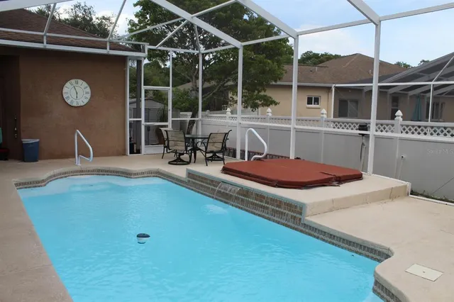a view of a house with pool and chairs