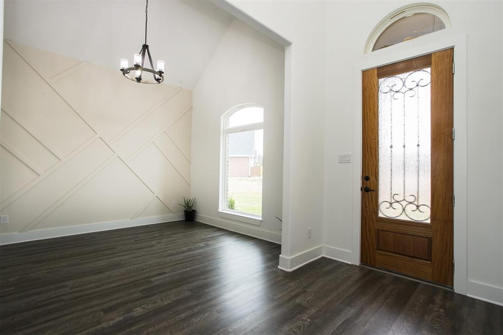 1006 Johnson Trail Bells, TX 75414 - Photo 2 of 19 an empty room with wooden floor chandelier and windows