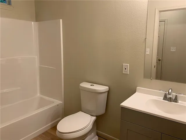 a white toilet sitting next to a bathroom sink