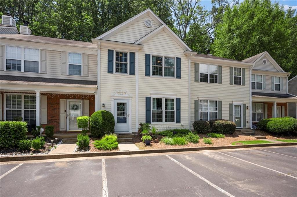 9155 Nesbit Ferry Road, Unit 85 Alpharetta, GA 30022 - Photo 1 of 1 a view of a white house with a yard plants and palm trees