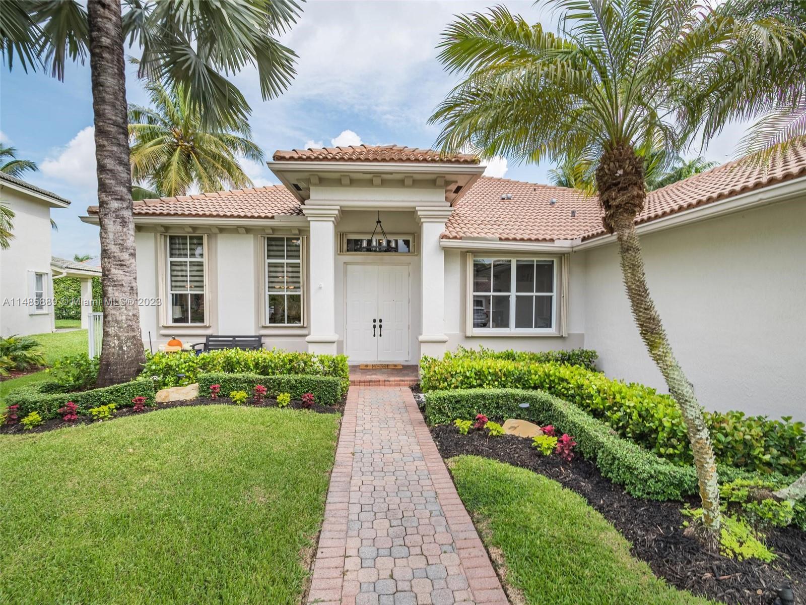 1955 Timberline Road Weston, FL 33327 - Photo 2 of 48 a front view of house with yard and green space