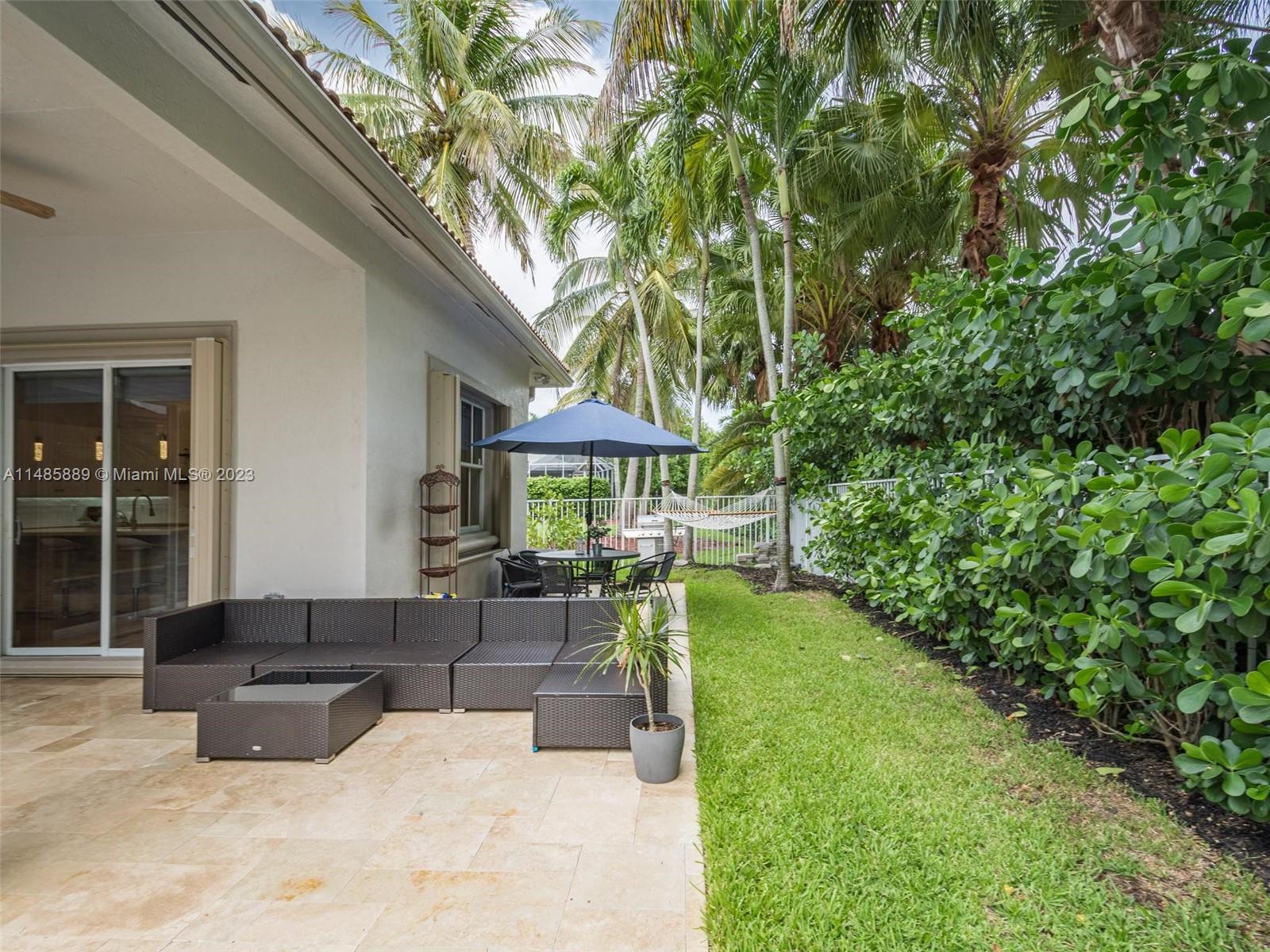 1955 Timberline Road Weston, FL 33327 - Photo 39 of 48 a patio with table and chairs and potted plants with large tree