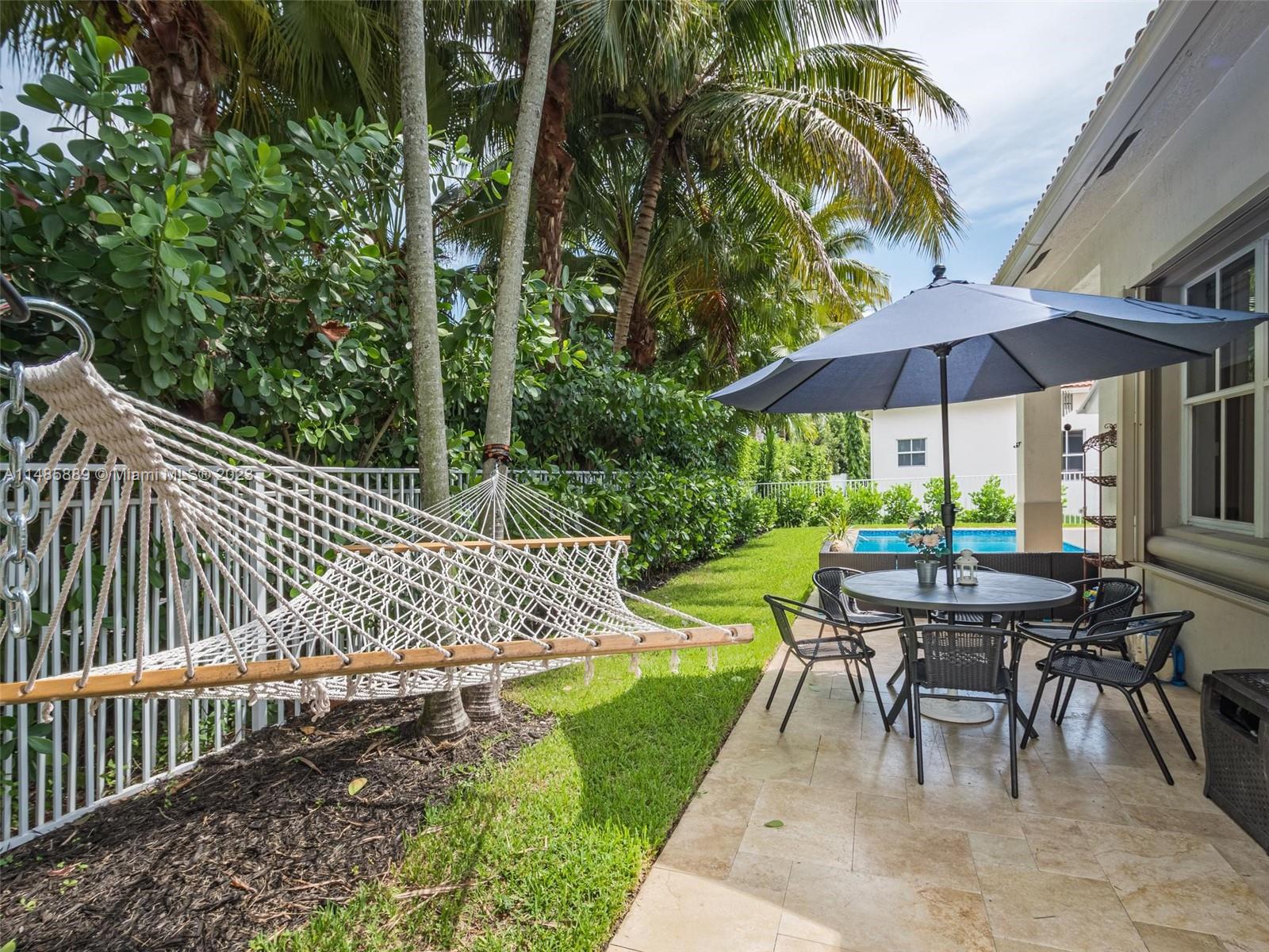 1955 Timberline Road Weston, FL 33327 - Photo 40 of 48 a view of a patio with a table and chairs under an umbrella