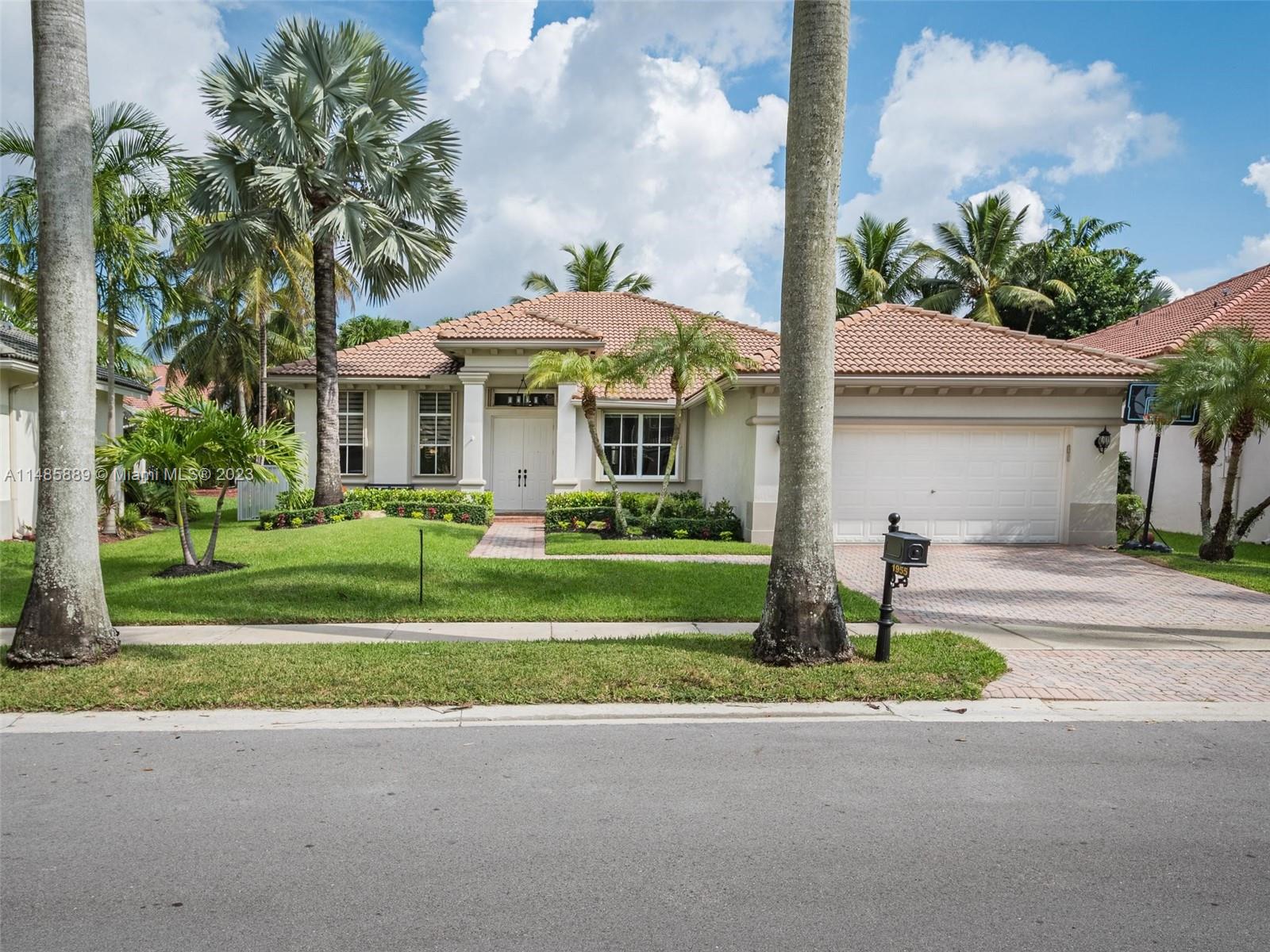 1955 Timberline Road Weston, FL 33327 - Photo 43 of 48 a front view of a house with a garden and trees