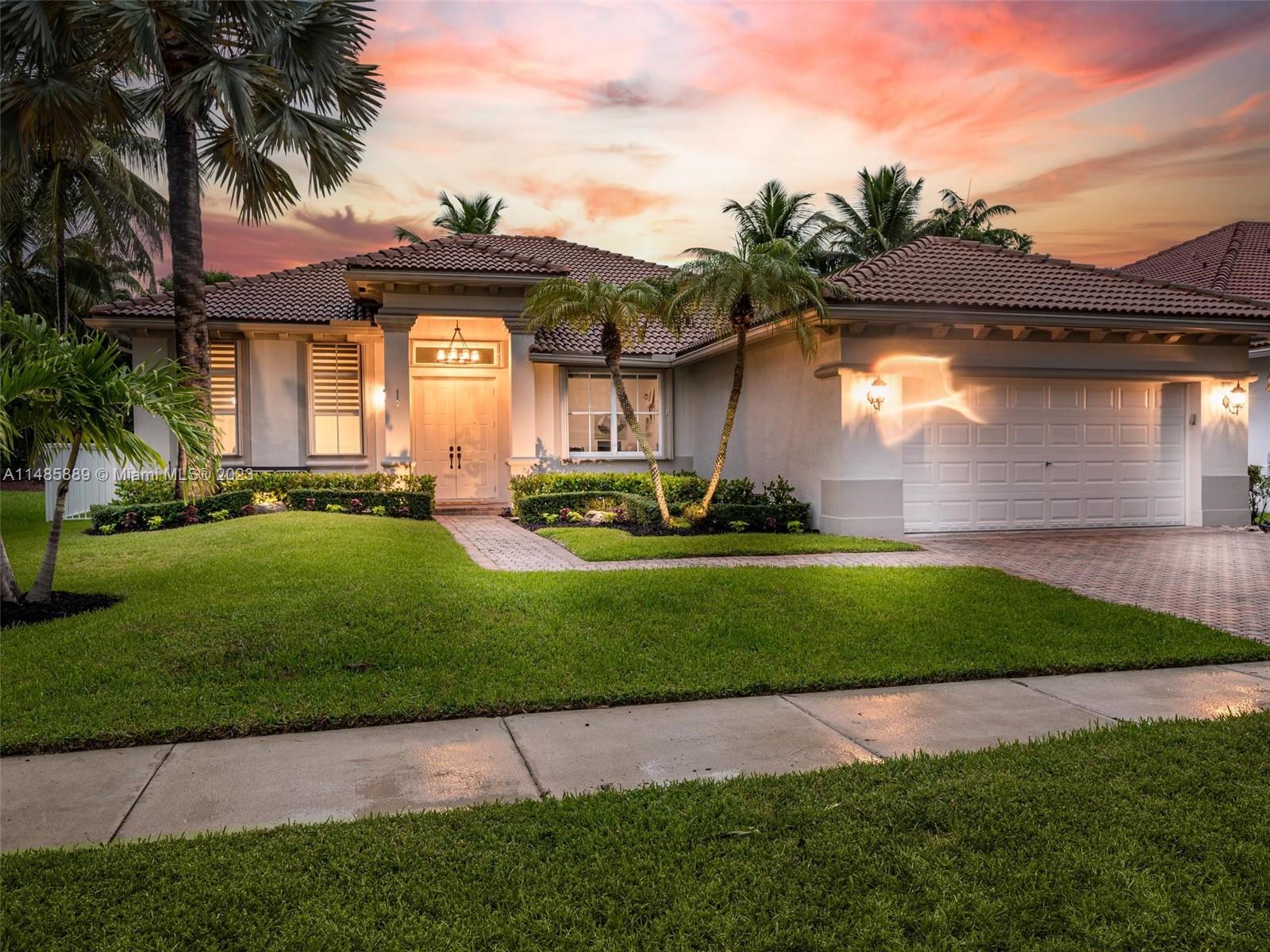 1955 Timberline Road Weston, FL 33327 - Photo 45 of 48 a front view of a house with a yard and potted plants