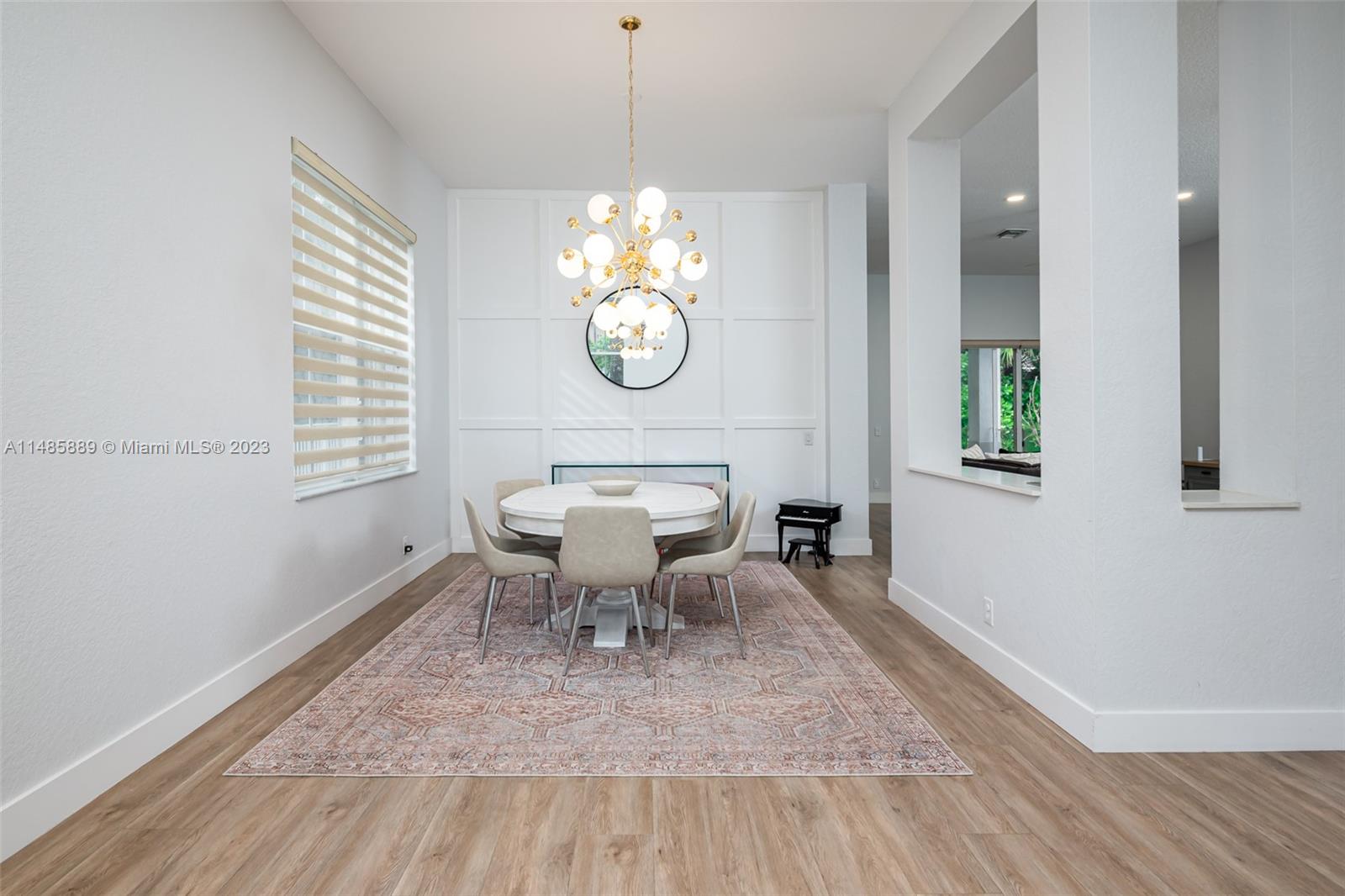 1955 Timberline Road Weston, FL 33327 - Photo 7 of 48 a view of dining room and livingroom with furniture wooden floor a rug and a chandelier