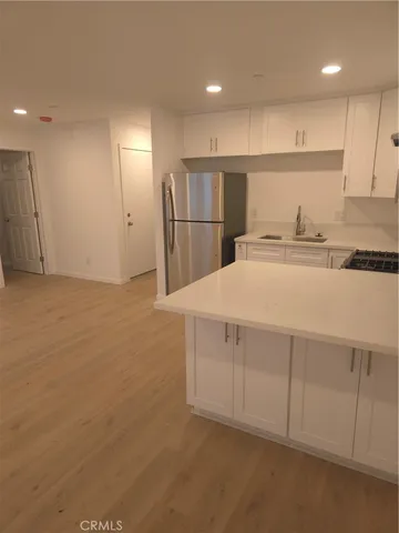 a kitchen with stainless steel appliances a refrigerator and a stove top oven