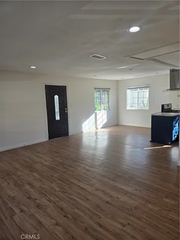 a view of empty room with wooden floor and window