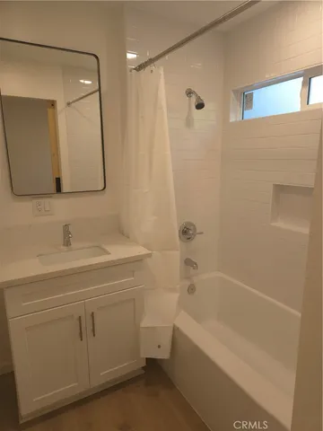 a bathroom with a bathtub a sink a toilet and a mirror