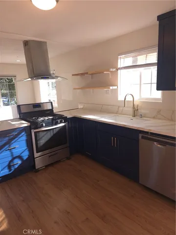 a kitchen with stainless steel appliances granite countertop a sink a stove a counter space and cabinets