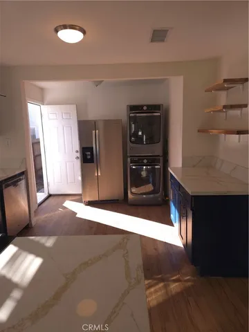a view of an empty room with a fireplace and cabinet