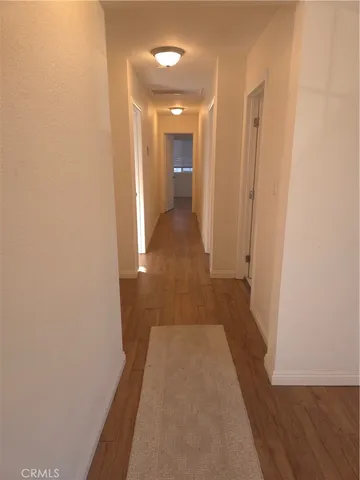 a view of a hallway with wooden floor