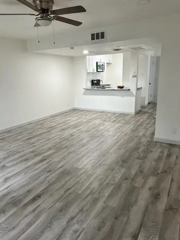 a view of a kitchen with a sink and wooden floor