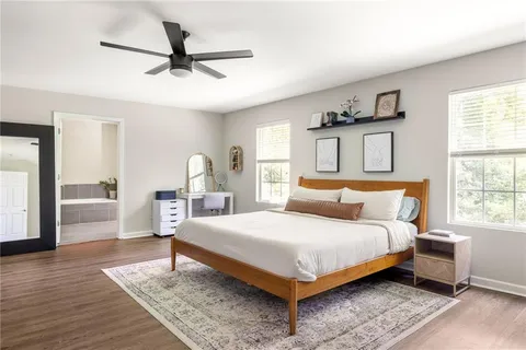 a bedroom with a bed wooden floor and window