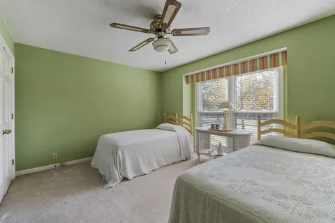 a bedroom with two beds and a large window