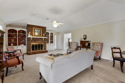 a living room with furniture a fireplace and a large window
