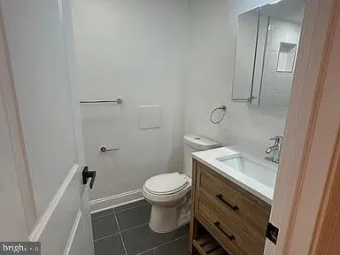 a bathroom with a granite countertop toilet and a sink