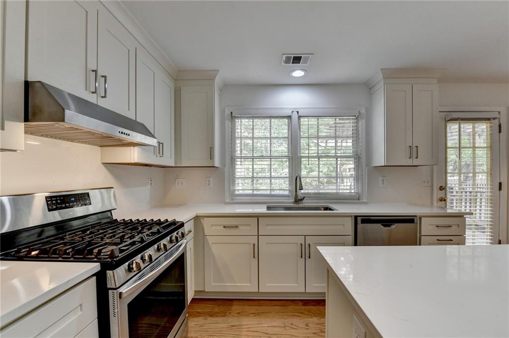 6535 Ganton Drive Duluth, GA 30097 - Photo 18 of 75 a kitchen with stainless steel appliances a sink stove and cabinets