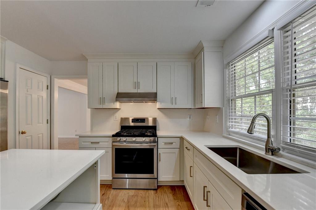 6535 Ganton Drive Duluth, GA 30097 - Photo 22 of 75 a kitchen with a white stove top oven and sink