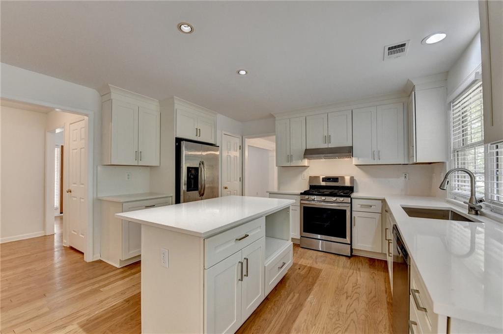 6535 Ganton Drive Duluth, GA 30097 - Photo 23 of 75 a kitchen with white cabinets and stainless steel appliances