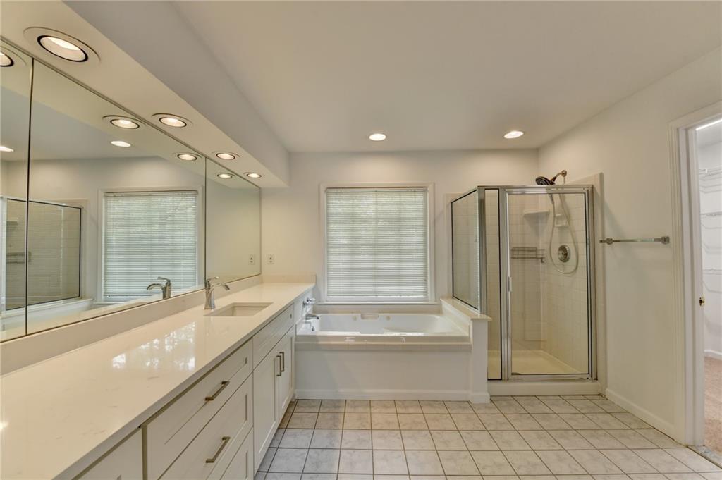 6535 Ganton Drive Duluth, GA 30097 - Photo 52 of 75 a bathroom with a granite countertop sink a toilet a mirror and shower