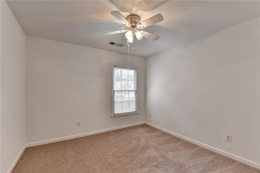 6535 Ganton Drive Duluth, GA 30097 - Photo 61 of 75 an empty room with windows and chandelier fan