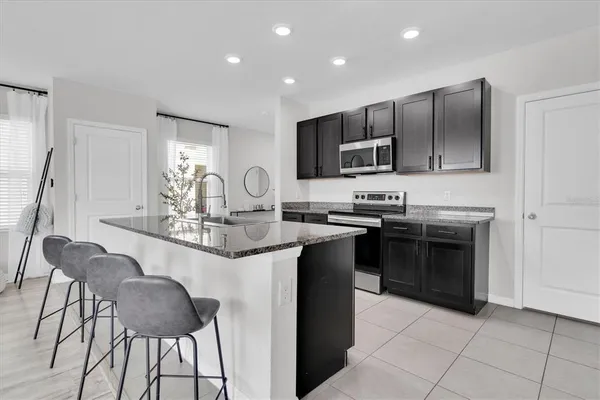 a kitchen with stainless steel appliances granite countertop a sink stove and refrigerator