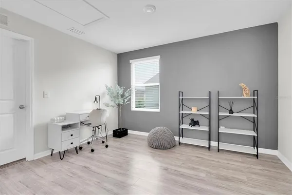 a view of an empty room with wooden floor and windows