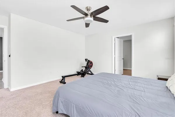 a bedroom with a bed and a ceiling fan