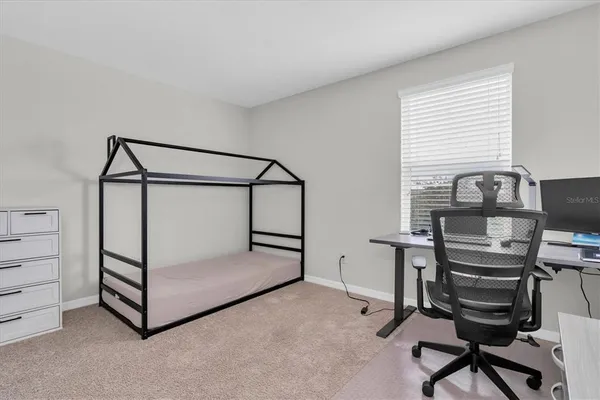 a view of a workspace with furniture and a window