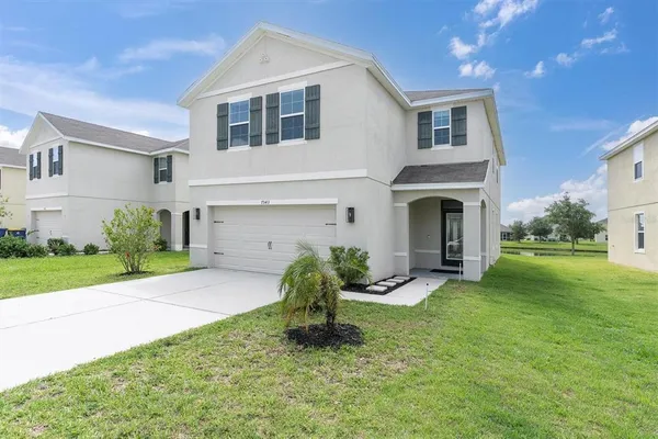 a front view of a house with a yard and garage