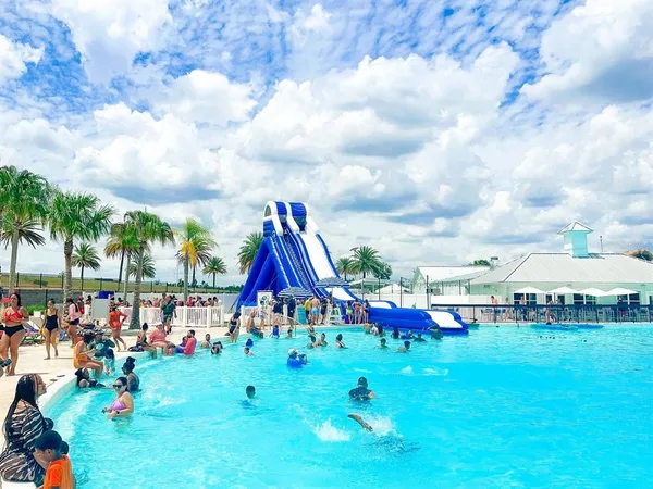 a view of swimming pool with lawn chairs and a yard