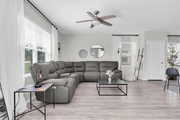 a living room with furniture and a wooden floor