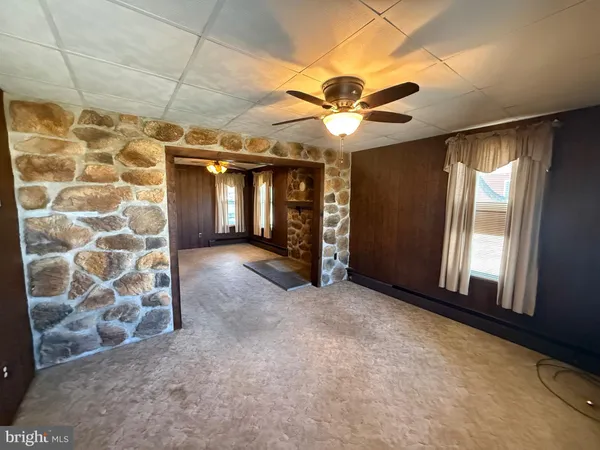an empty room with windows and fan