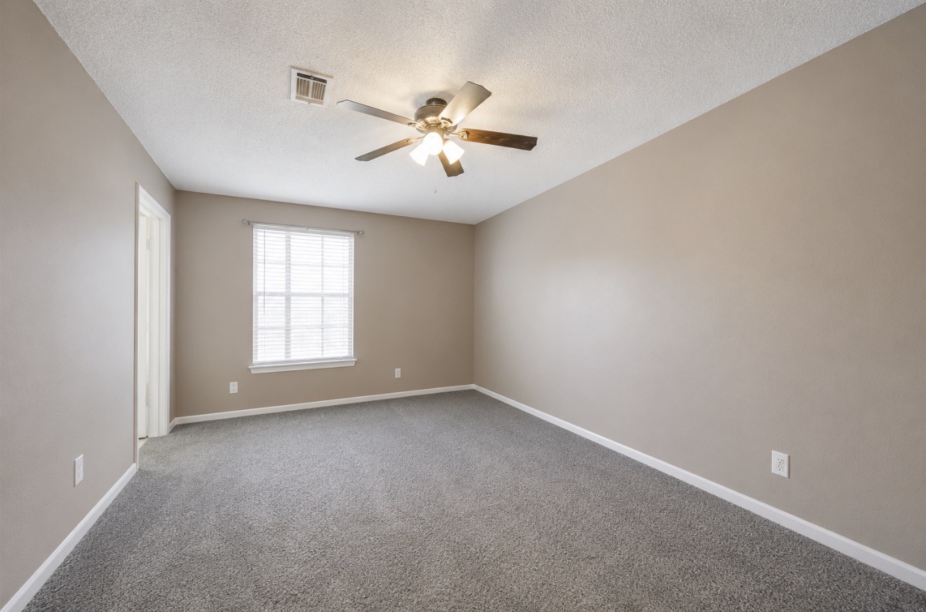 3728 Autumn Lane Baytown, TX 77521 - Photo 11 of 16 This room features neutral walls, a ceiling fan, and a soft carpet, creating a cozy ambiance. Natural light streams through a large window.