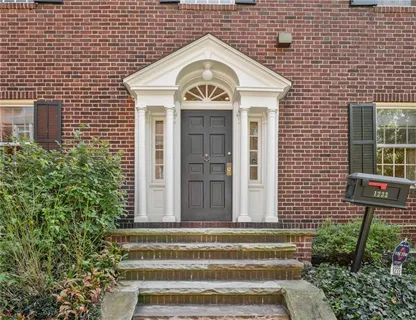 a view of a brick house with plants and large windows