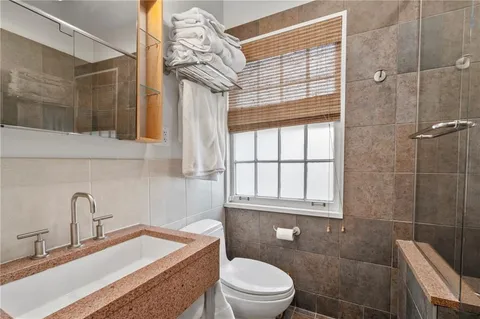 a bathroom with a sink a toilet and shower