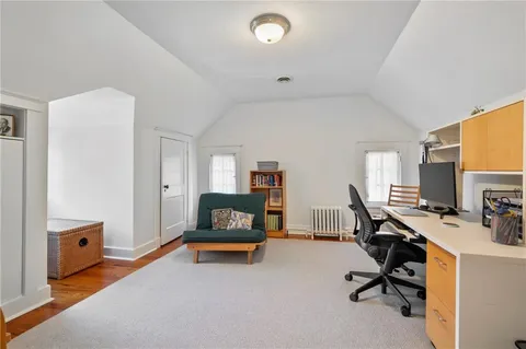a view of a workspace with furniture and a window