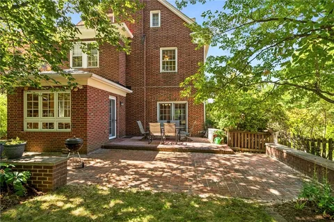 a front view of a house with a tree
