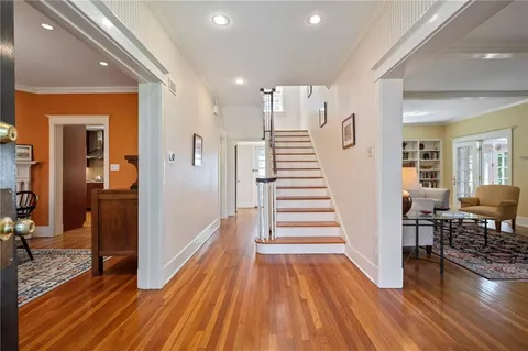 a view of a hallway with wooden floor fireplace and livingroom view