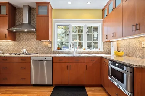 a kitchen with stainless steel appliances granite countertop a sink and a stove