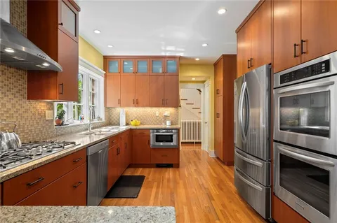 a kitchen with stainless steel appliances kitchen island granite countertop a stove a sink and a refrigerator
