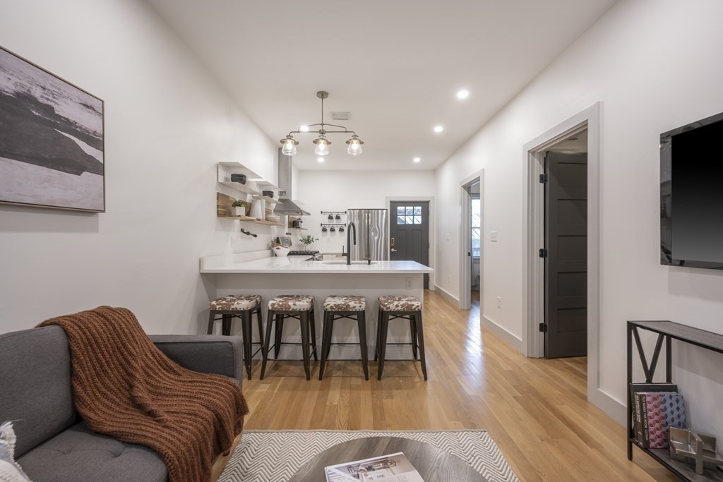 43 Wordsworth Street, Unit 2 Boston, MA 02128 - Photo 2 of 13 a living room with furniture a flat screen tv and kitchen view