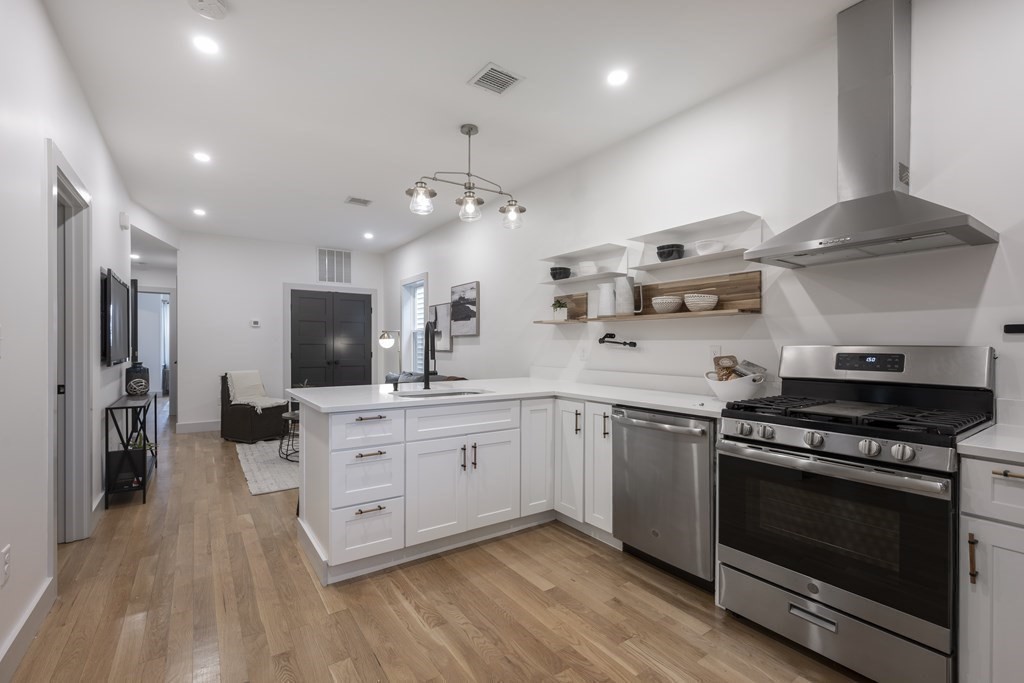 43 Wordsworth Street, Unit 2 Boston, MA 02128 - Photo 4 of 13 a kitchen with stainless steel appliances a stove top oven a sink dishwasher and a refrigerator with wooden floor